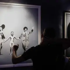 Wystawa "Banksy zdemaskowany" prezentuje dzieła artysty, w tym obraz z postaciami Myszki Miki i Ronalda McDonalda trzymających się za ręce.