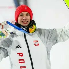 Kacper Tomasiak z medalem i nartami, dumny reprezentant Polski. Jego rodzina z pewnością cieszy się z sukcesu.