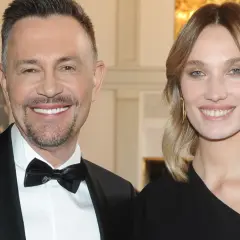 Krzysztof Ibisz z żoną, uśmiechnięci, elegancko ubrani na gali.