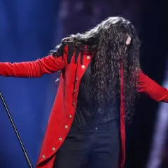 Michał Szpak w czerwonym fraku śpiewa na Eurowizji 2016.