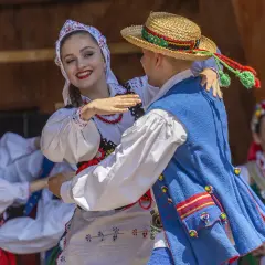 Para tańczy w tradycyjnych polskich strojach ludowych.