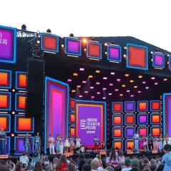 Koncert "Lato z Radiem i Telewizją Polska" w Zakopanem. Kolorowa scena z neonami i ekranami LED, artyści na scenie i tłum widzów.
