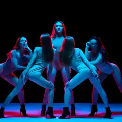 Pięć kobiet w body i butach na obcasach wykonuje zmysłowy taniec high heels w neonowym świetle.