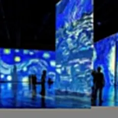 Wystawa Van Gogh w Bydgoszczy. Widzowie podziwiają projekcje "Gwiaździstej nocy" na ścianach i podłodze.