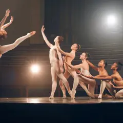 Tancerki na scenie prezentują różne rodzaje tańca, od dynamicznych skoków po eleganckie pozy.