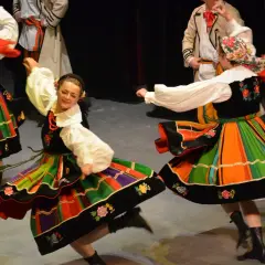 Tancerze w tradycyjnych polskich strojach ludowych wykonują taniec oberek.