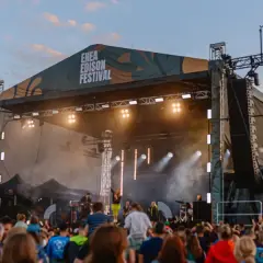 Koncert na Enea Edison Festival. Tłum ludzi przed sceną, na której gra zespół.