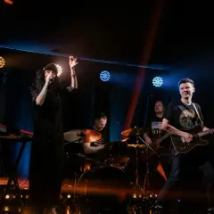 Zespół rockowy na scenie: wokalistka, gitarzysta, perkusista i klawiszowiec.