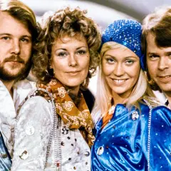 Zespół ABBA w strojach scenicznych, uśmiechnięci, patrzą w obiektyw.