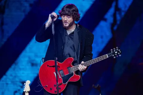 James Arthur śpiewa i gra na czerwonej gitarze na koncercie w Warszawie.