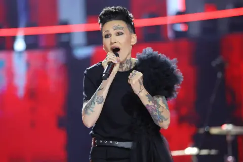 Agnieszka Chylińska śpiewa na scenie, przygotowując się do koncertów w 2026 roku. Jej charakterystyczny styl i tatuaże przyciągają wzrok.