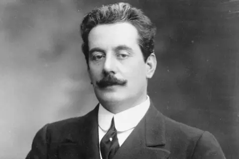 Portret Giacomo Pucciniego w garniturze i z wąsami.