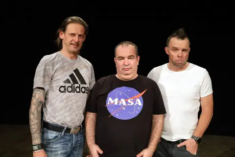Trzech mężczyzn na czarnym tle. Jeden w koszulce Adidas, drugi w koszulce z logo NASA, trzeci w białej koszulce.