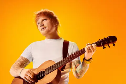 Ed Sheeran z gitarą, gotowy na koncerty w 2025 roku.