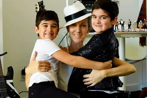 Celine Dion z synami, bliźniakami Eddy'm i Nelsonem, w otoczeniu gitar i figurek Michaela Jacksona.