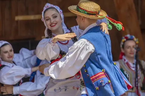 Para tańczy w tradycyjnych polskich strojach ludowych.
