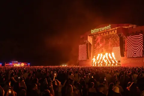 Koncert na festiwalu Bittersweet z płomieniami i tłumem widzów.