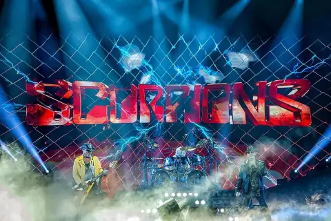 Zespół Scorpions na scenie TAURON Areny, w tle logo zespołu i efekty świetlne.