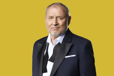 Andrzej Grabowski w garniturze, znany z wielu niezapomnianych ról w polskich filmach.