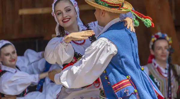 Para tańczy w tradycyjnych polskich strojach ludowych.