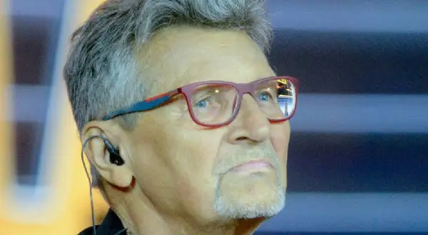 Jacek Zieliński w okularach, z słuchawką w uchu, patrzy w dal.