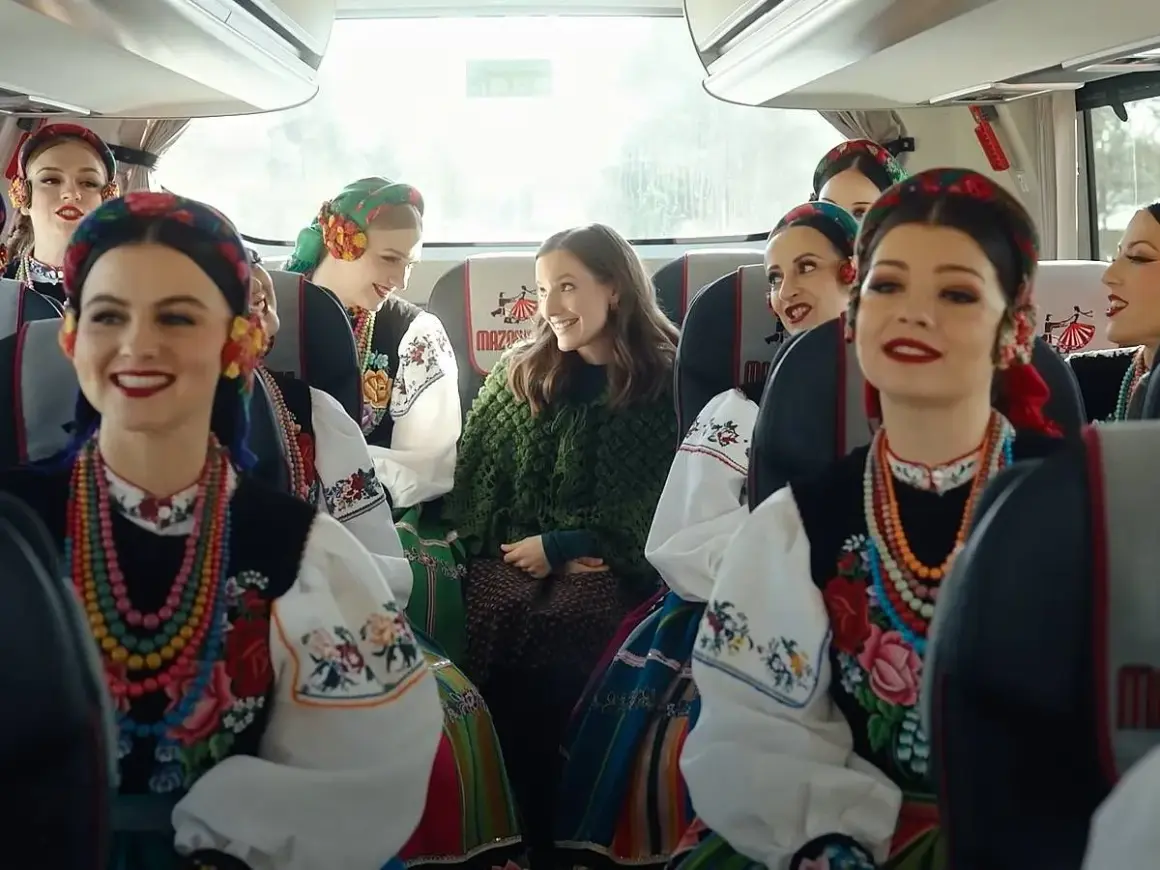 Uśmiechnięte dziewczyny w strojach ludowych, podróżujące autobusem Mazda. Kolorowe korale i haftowane bluzki.