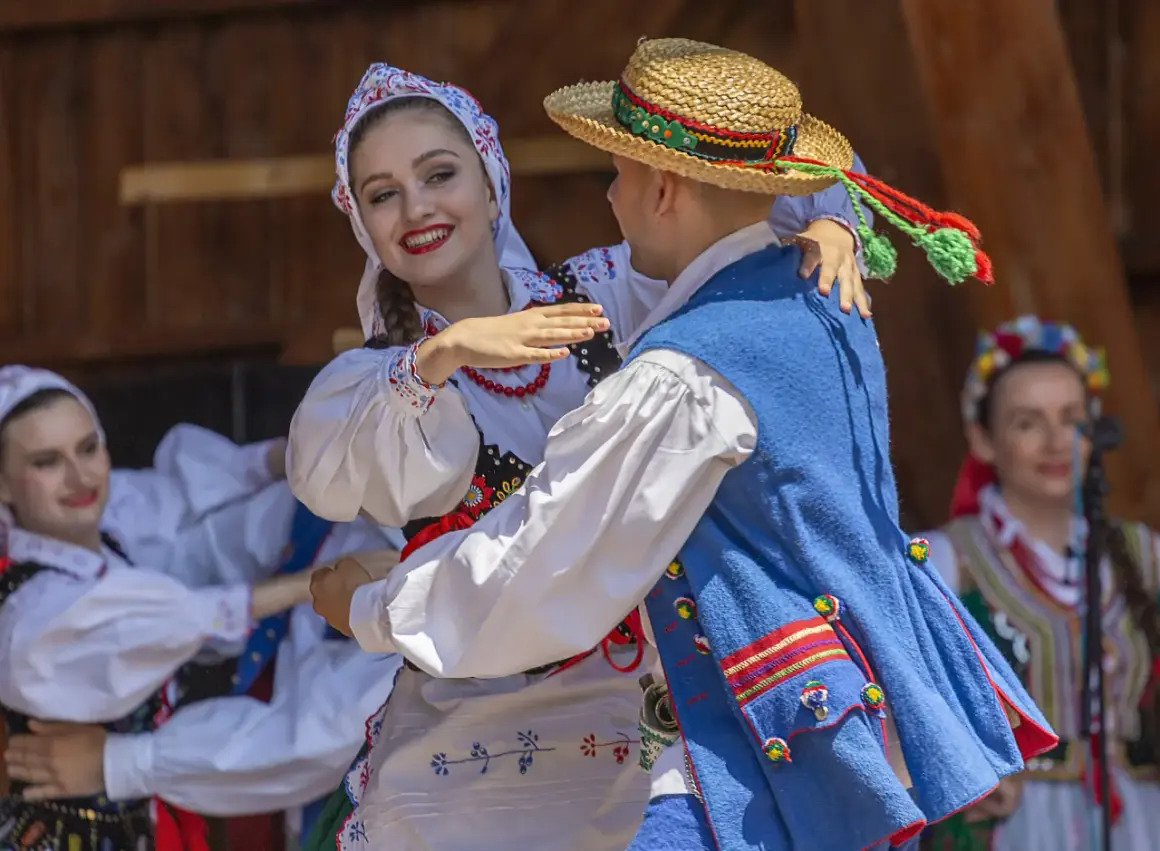 Para tańczy w tradycyjnych polskich strojach ludowych.