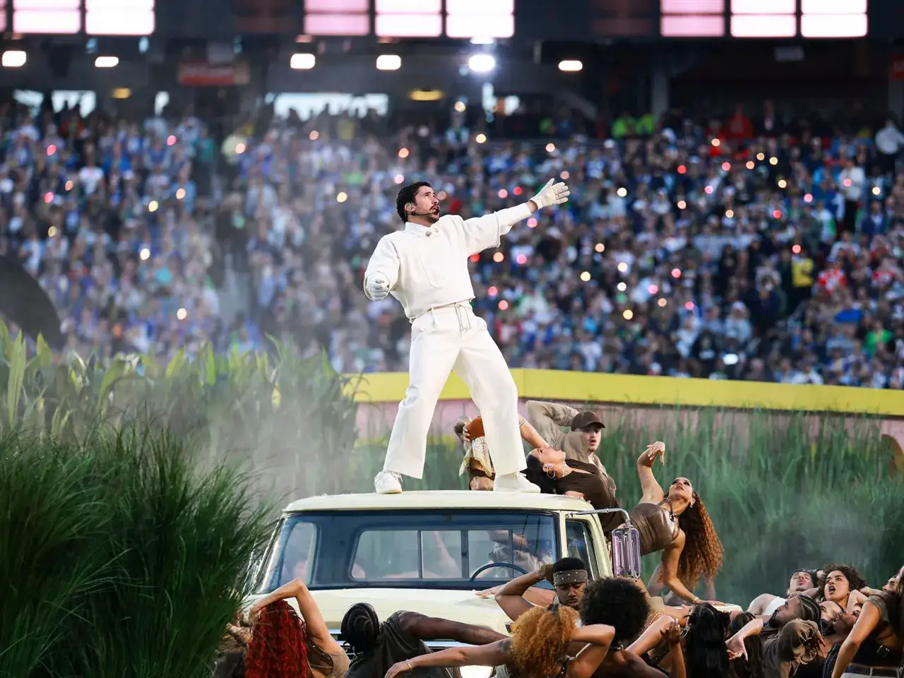 Bad Bunny na scenie podczas Super Bowl, otoczony tancerzami na tle tłumu.