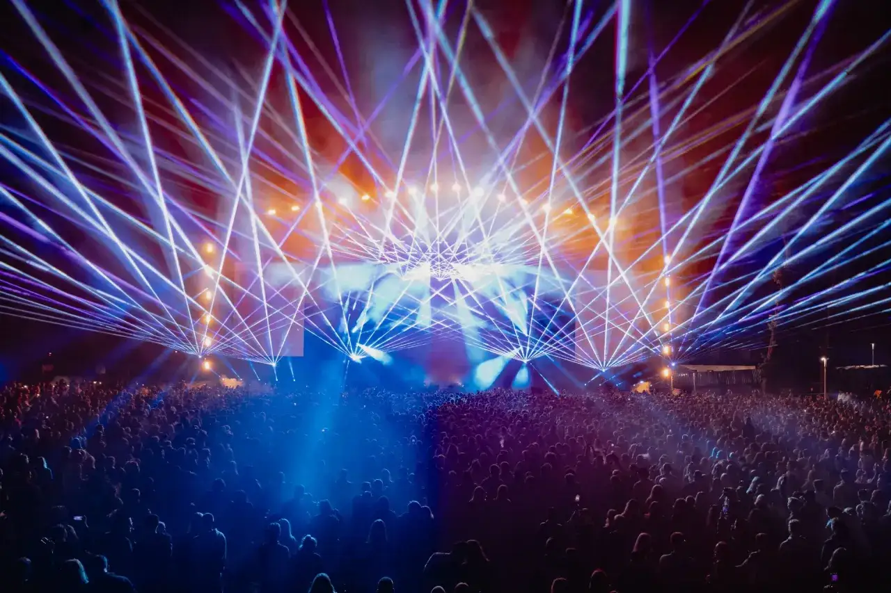 Tłum ludzi na koncercie, nad którym rozpościera się laserowy pokaz świateł. To był prawdziwy banger!