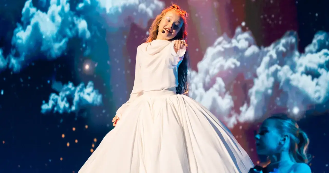 Dziewczynka w białej sukni na scenie, przygotowuje się do występu na Eurowizji Junior.