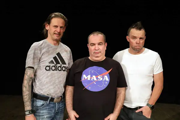 Trzech mężczyzn na czarnym tle. Jeden w koszulce Adidas, drugi w koszulce z logo NASA, trzeci w białej koszulce.