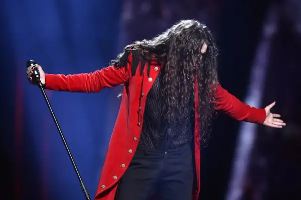 Michał Szpak w czerwonym fraku śpiewa na Eurowizji 2016.