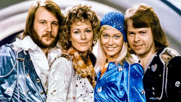 Zespół ABBA w strojach scenicznych, uśmiechnięci, patrzą w obiektyw.
